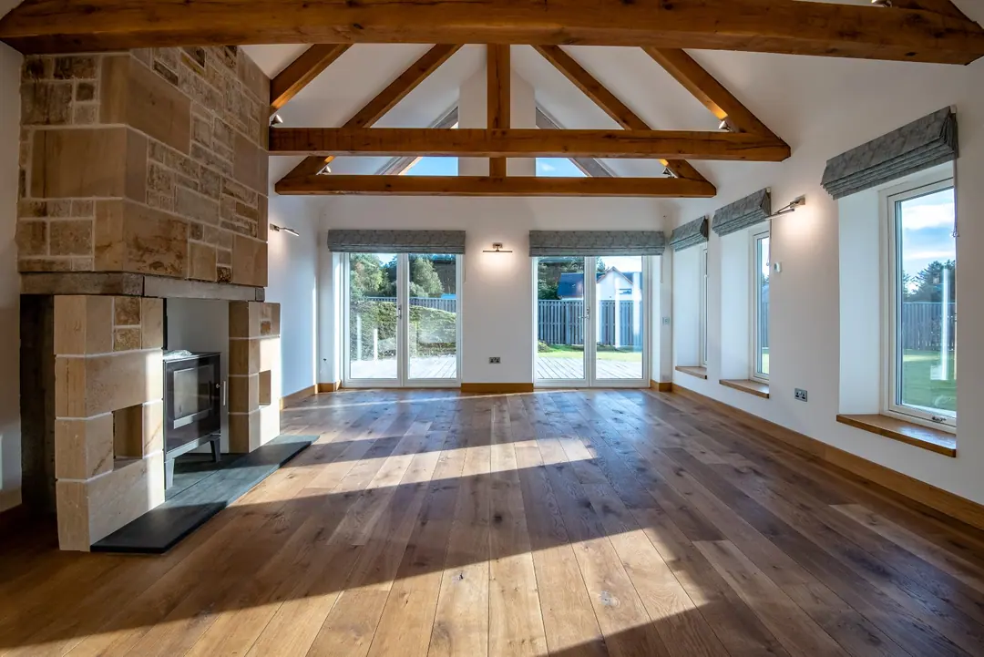 Sunlit barn conversion living room with oak beams