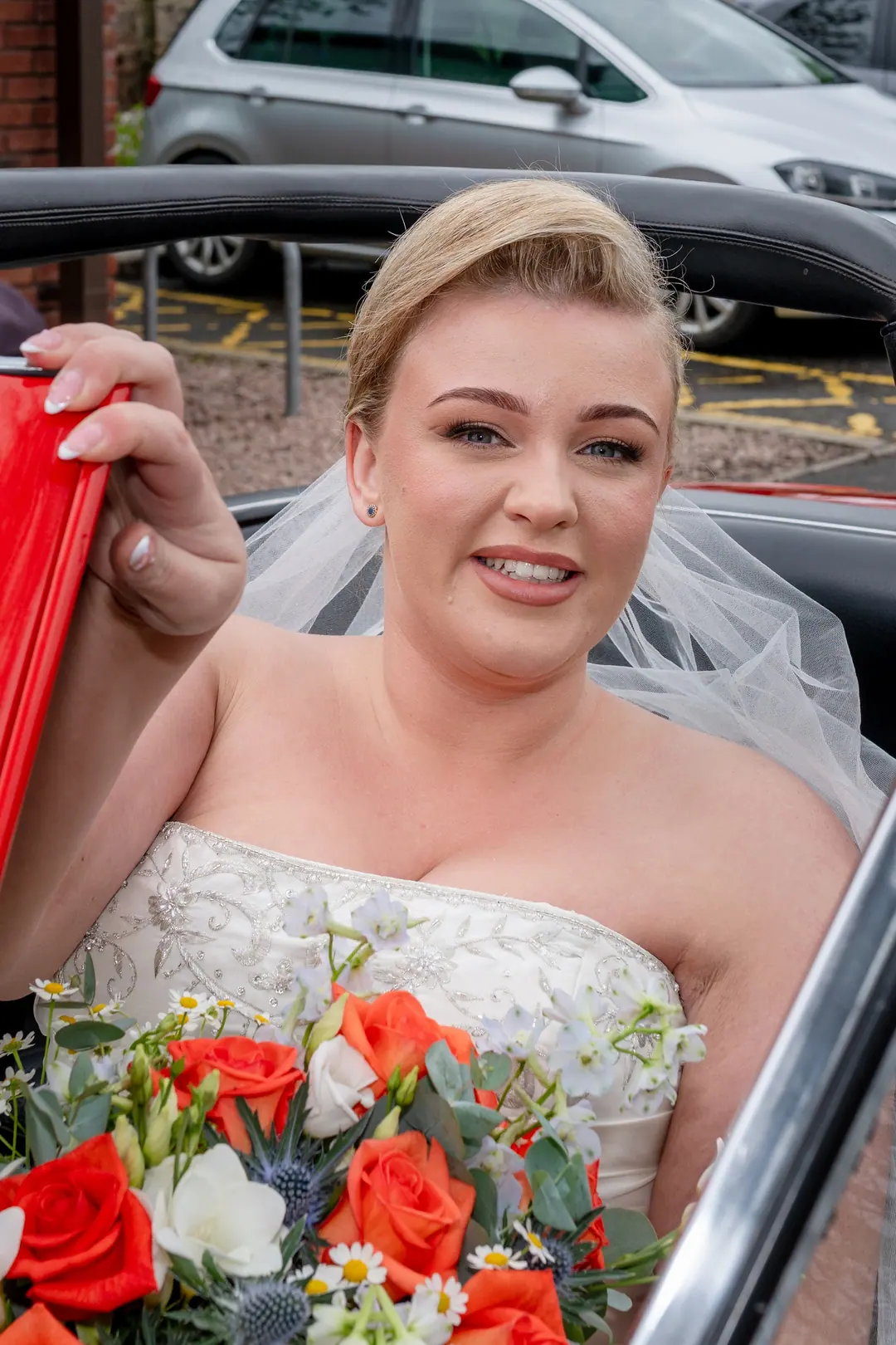 Bride smiling from a classic car outside the Glenmoriston Townhouse