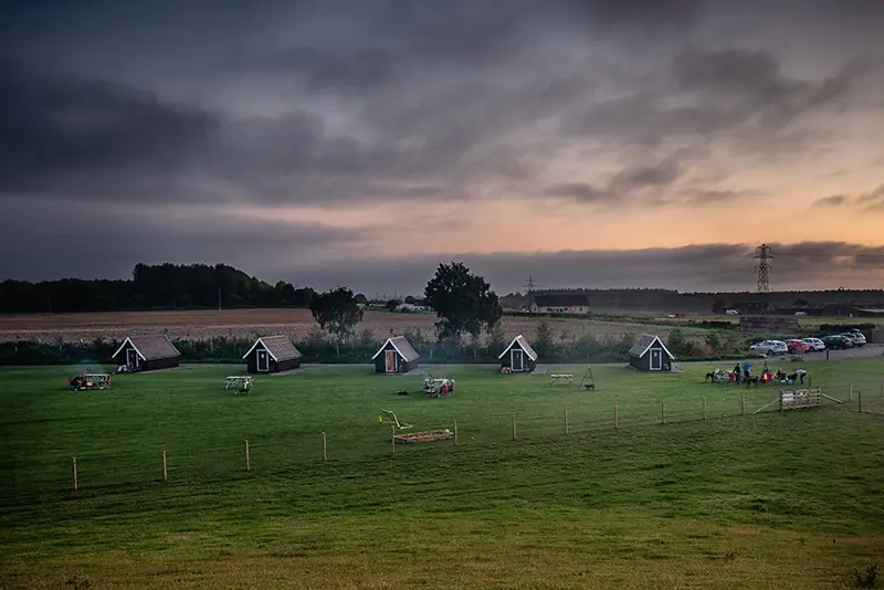 Holiday lodges at dusk under a dramatic sky