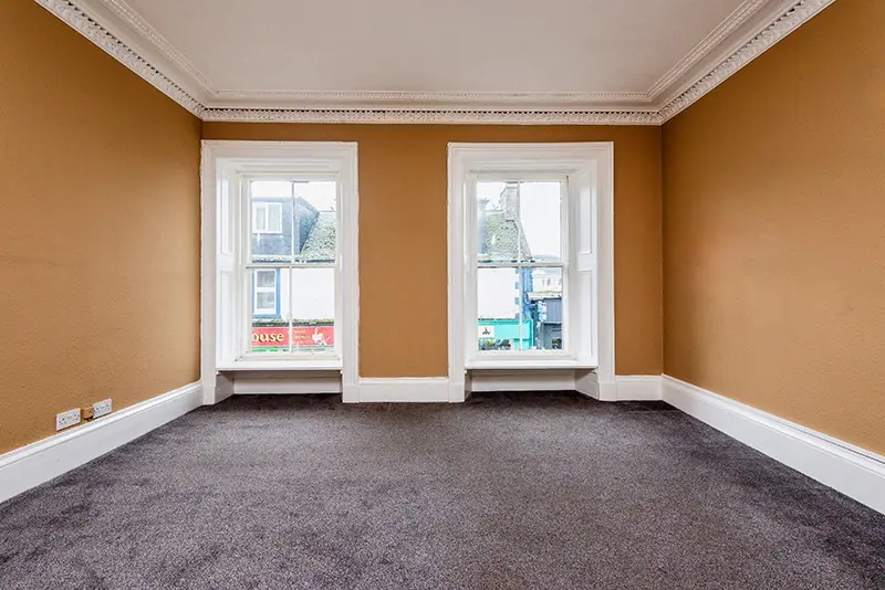 Empty period room with tall windows