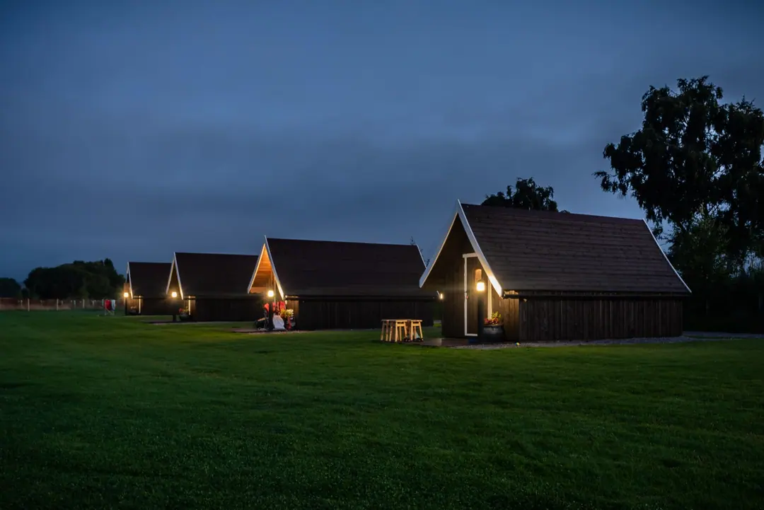 Glamping pods glowing at dusk