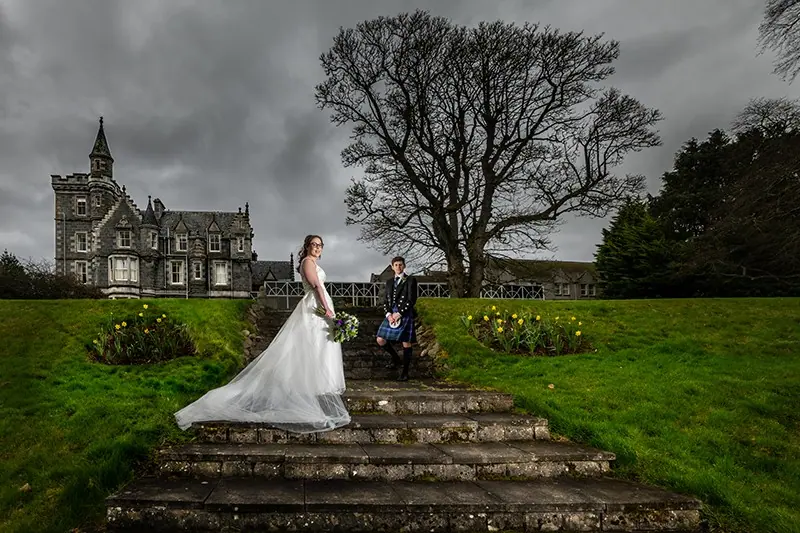 Couple on the steps of a castle beside a great tree