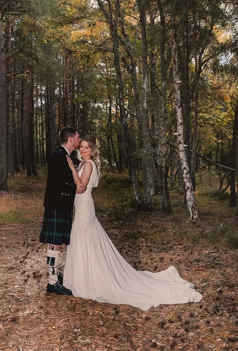 Bride and groom in a pine forest in autumn