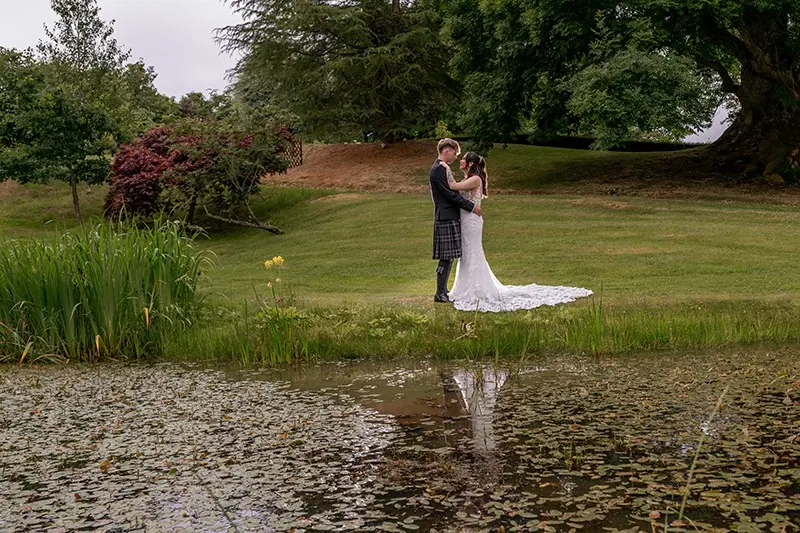 Couple beside a lily pond in a formal garden