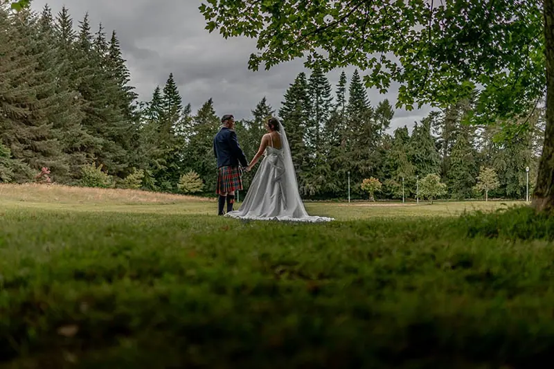 Couple on a lawn edged with pine trees