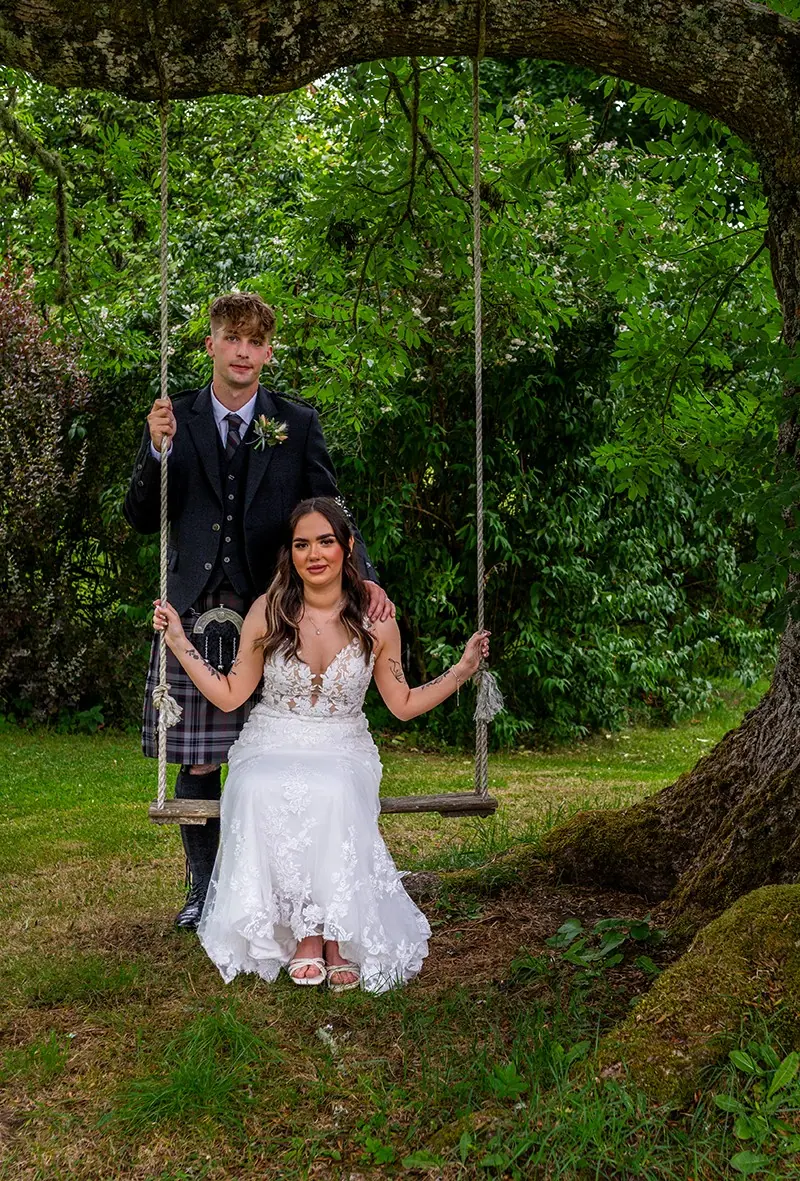 Bride on a garden swing beneath trees