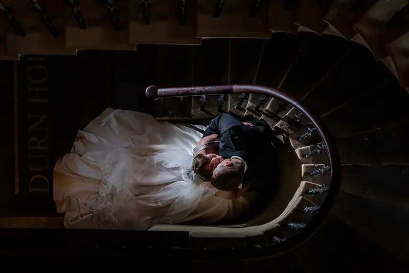 Looking down a spiral staircase at a bride's gown