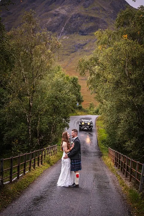 Couple on a bridge on a tree-lined Highland road