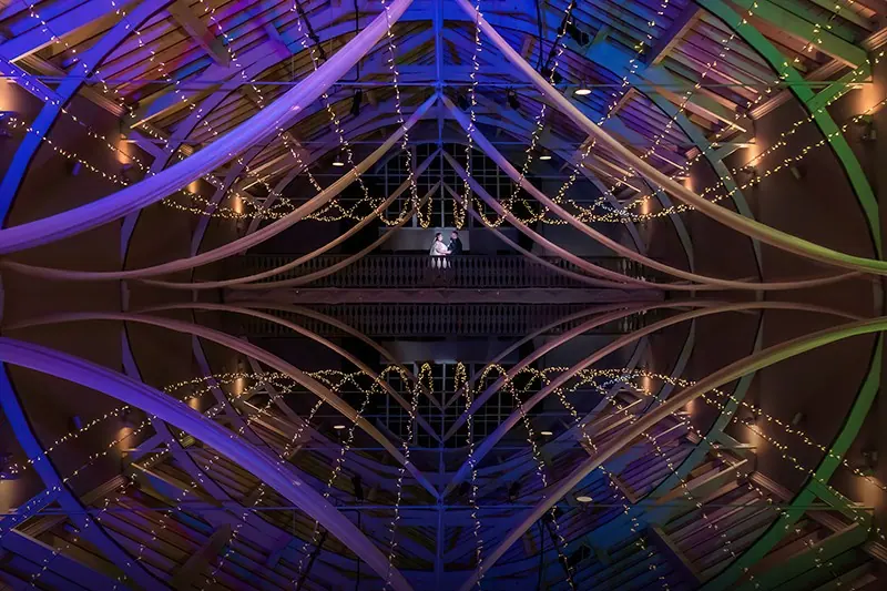 Kaleidoscopic reflection of a couple under coloured lights