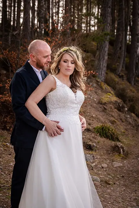 Bride and groom smiling in a pine forest