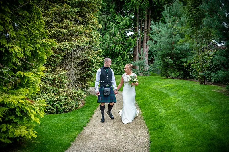 Couple on a garden path, groom in a kilt